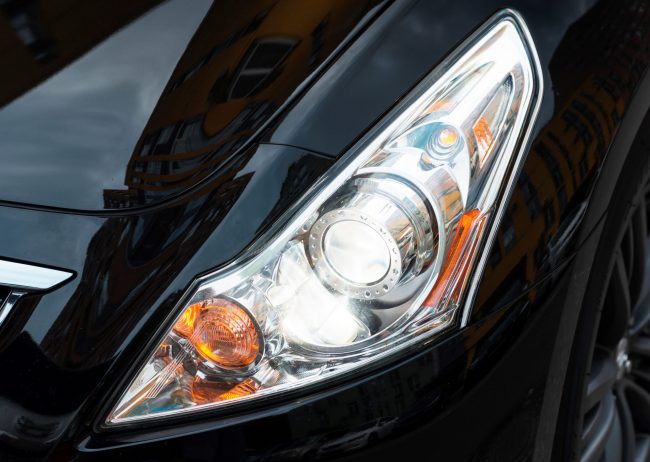 Closeup of headlights and high beams of white car.