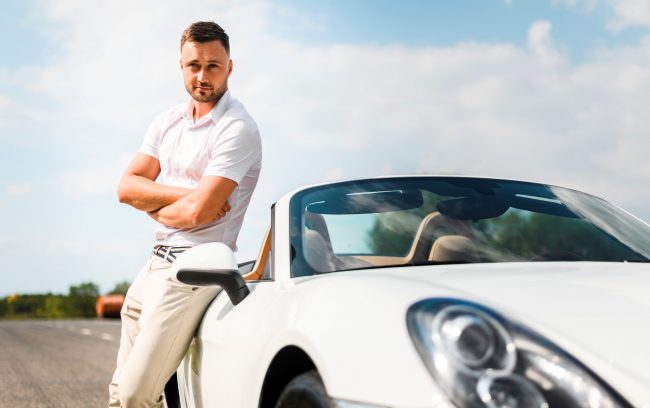 Man leaning against car illustrates blog "WHAT IS A VIN NUMBER AND WHY IS IT IMPORTANT?"