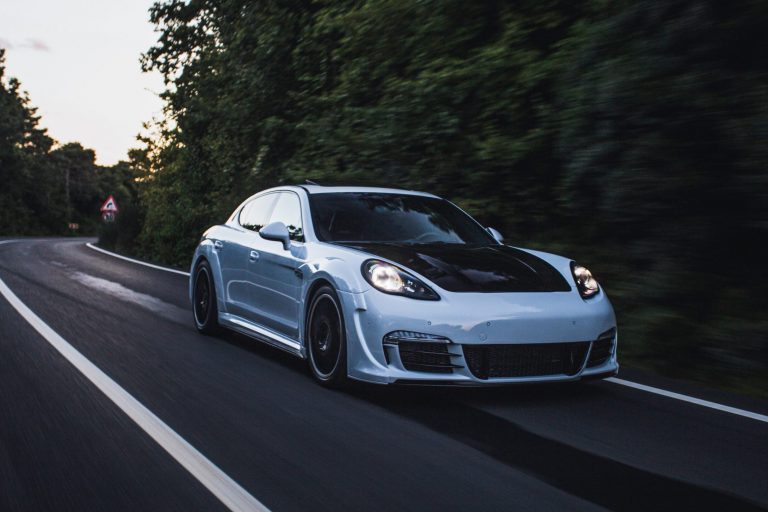 Sports car in highway with trees in the background illustrates blog "What Are the Effects of a Faulty Radiator Support?"
