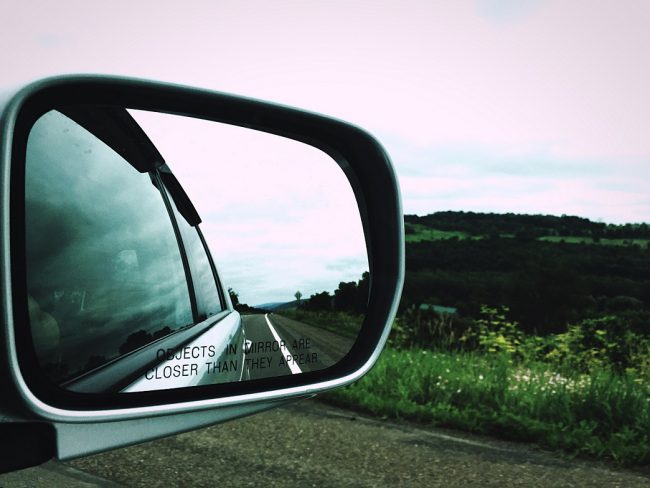 Side view mirror reflecting road illustrates blog "Why Does My Side View Mirror Shake?"